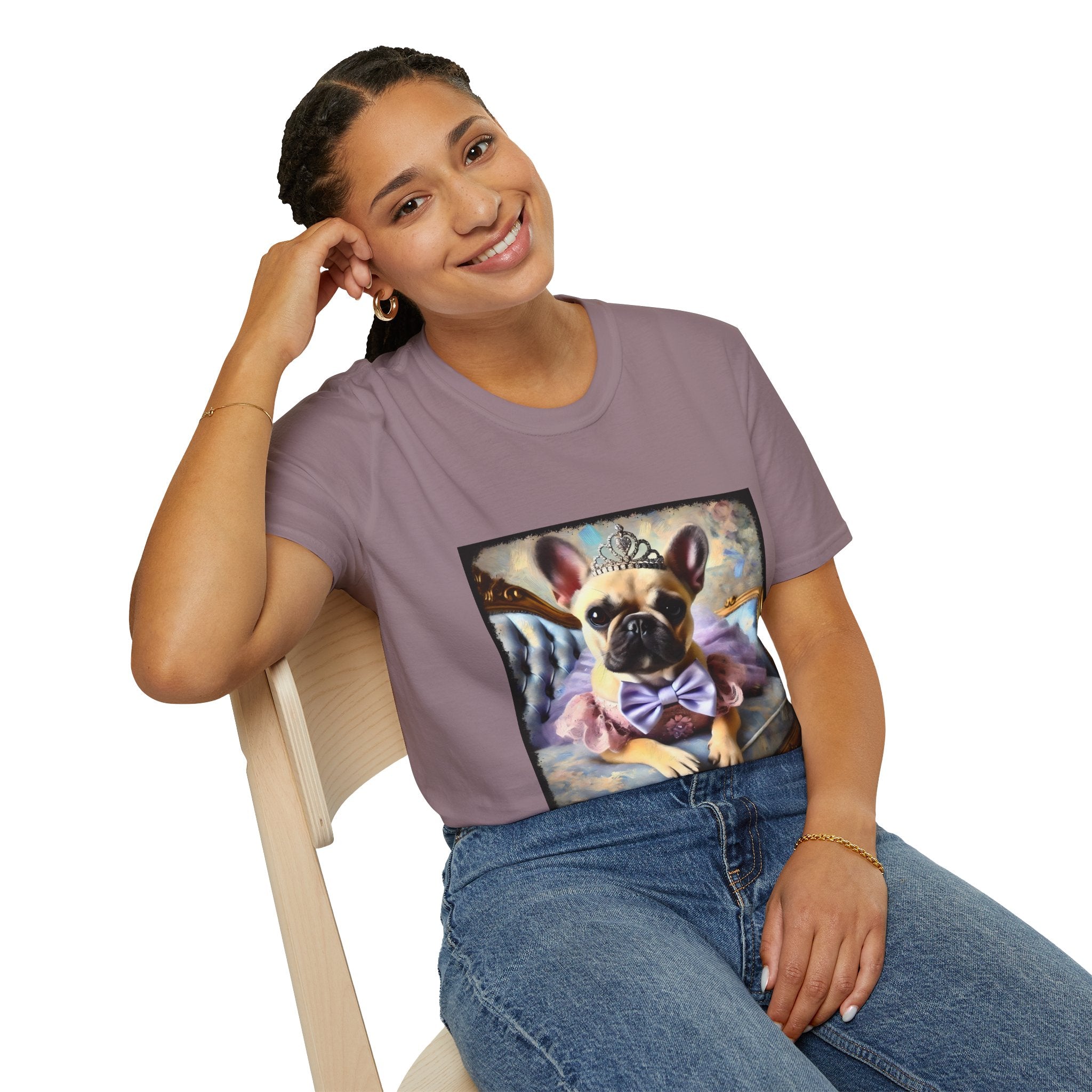 Woman sitting in mauve dog t-shirt featuring French Bulldog in tiara and tutu on royal chair with dreamy pastel background.