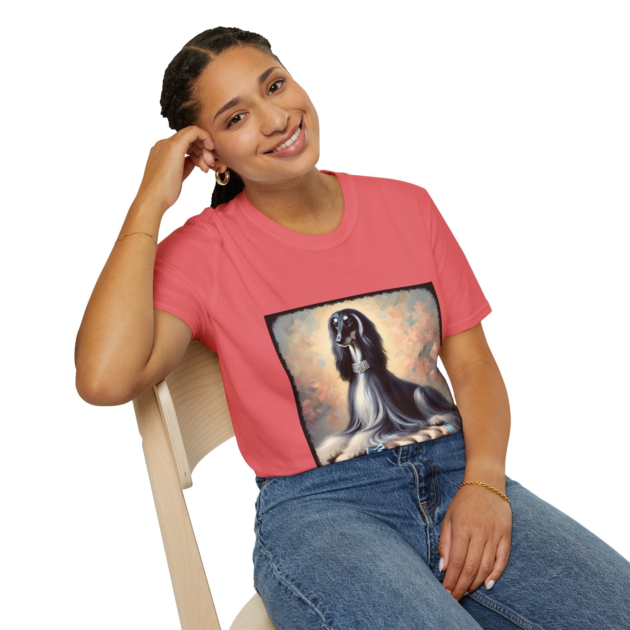 Front view of woman wearing  coral dog t-shirt featuring black and white Afghan Hound on cushion with diamond necklace, pastel background