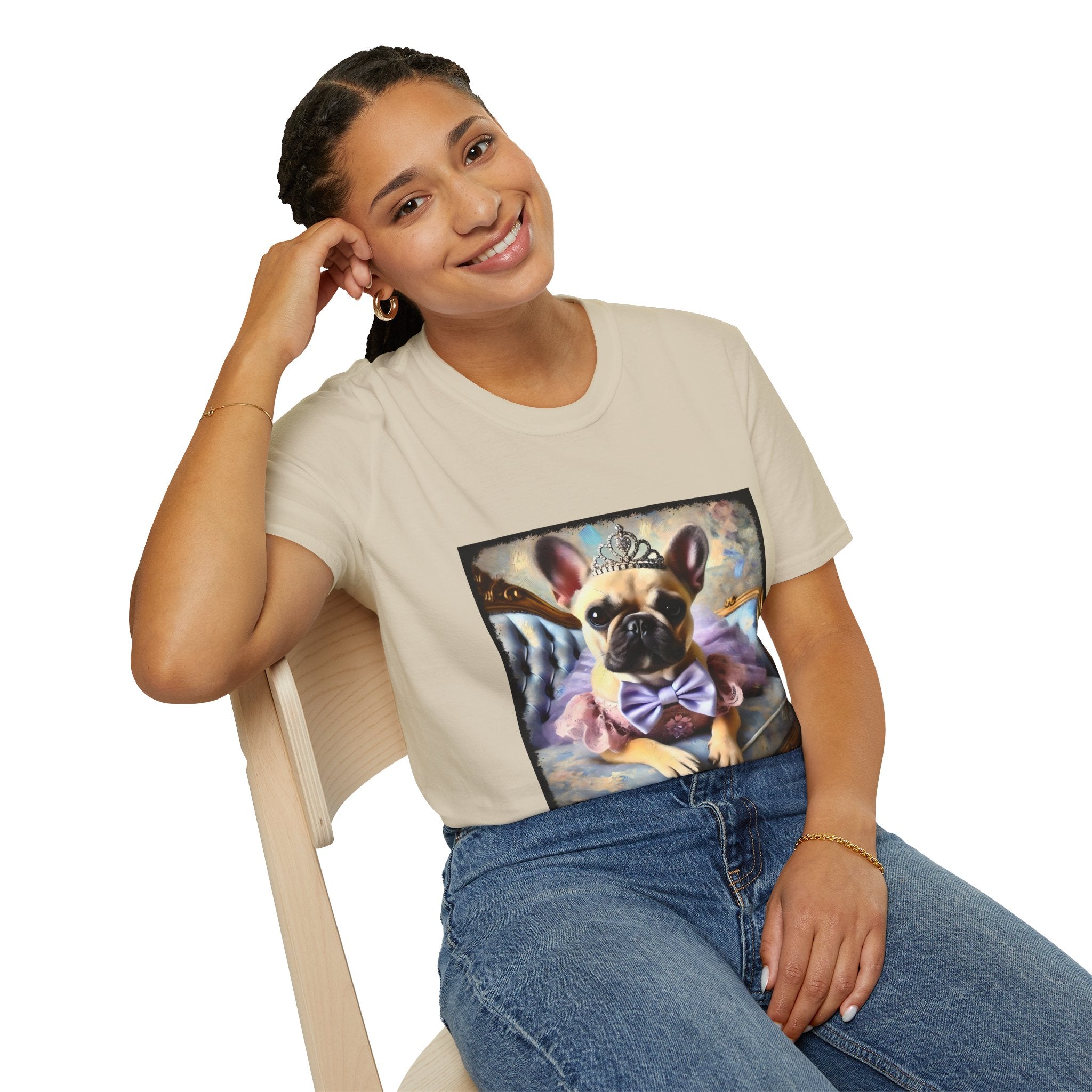 Woman sitting in beige dog t-shirt featuring French Bulldog in tiara and tutu on royal chair with dreamy pastel background.