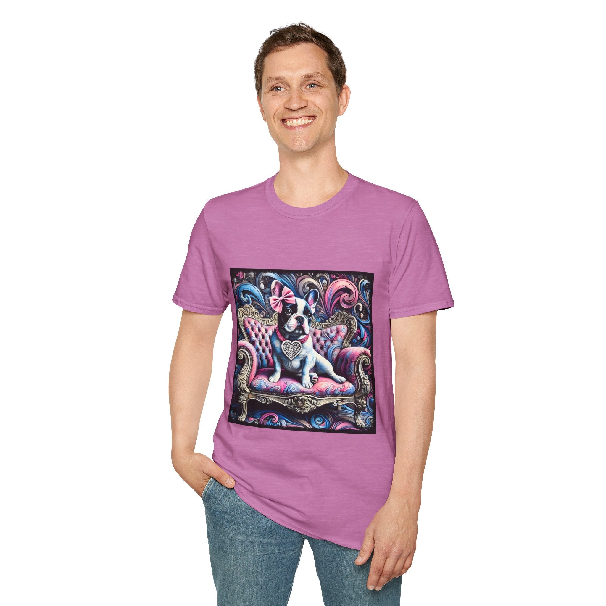 Male model in lilac rose dog t-shirt featuring a black and white French Bulldog with a pink bow, seated on a tufted pink and gold settee against a swirling blue, pink, and purple expressionist-style background.