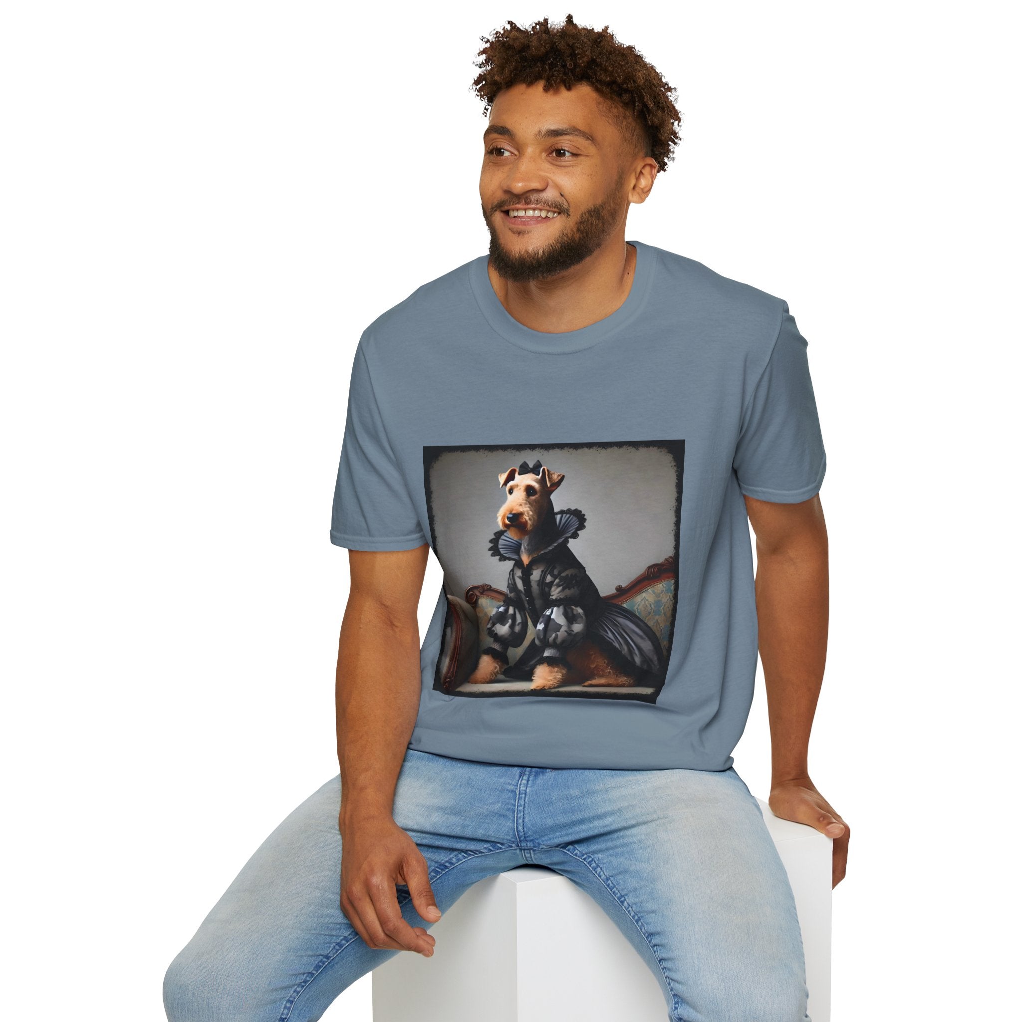 Male model in stone blue dog t-shirt featuring Airedale terrier in camouflage Renaissance gown seated on settee.