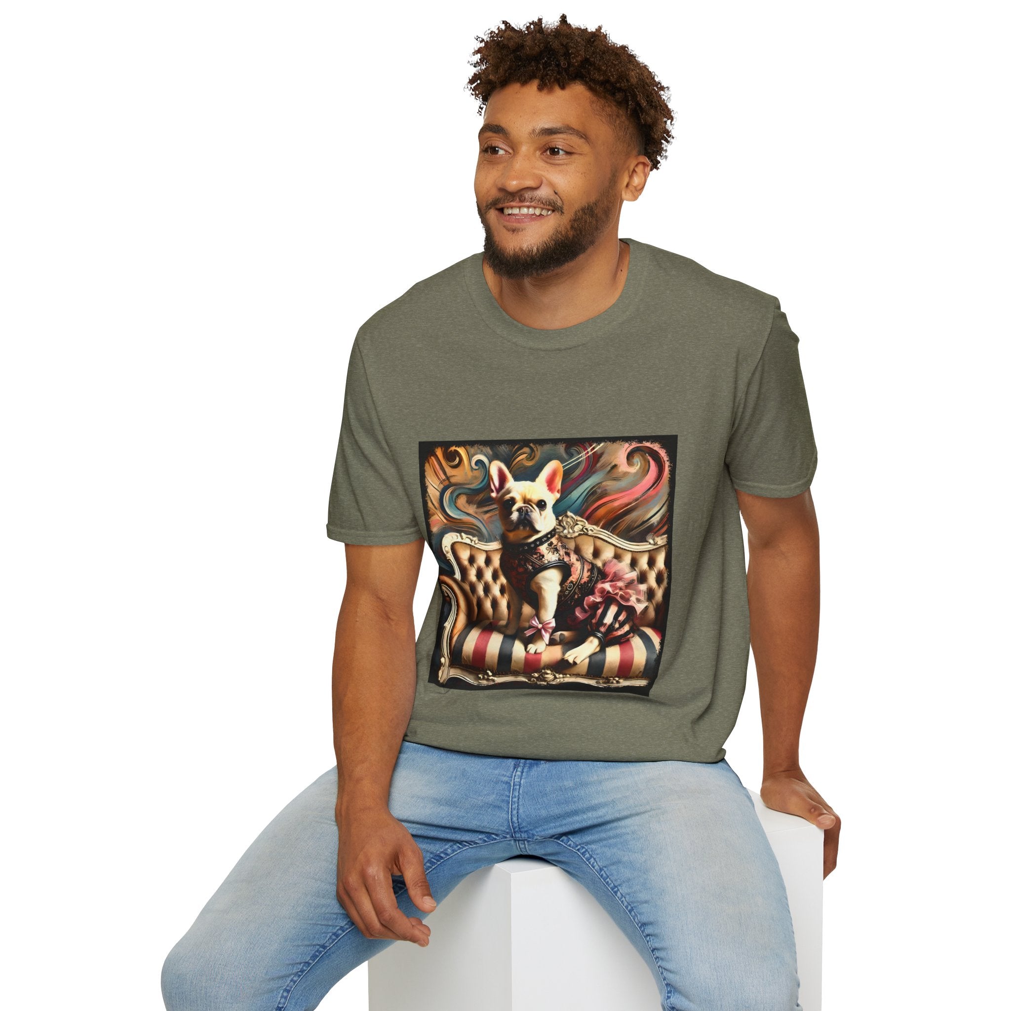 Male model in heather military green dog t-shirt featuring cream French Bulldog in floral vest and pink bow on striped settee with swirl background.