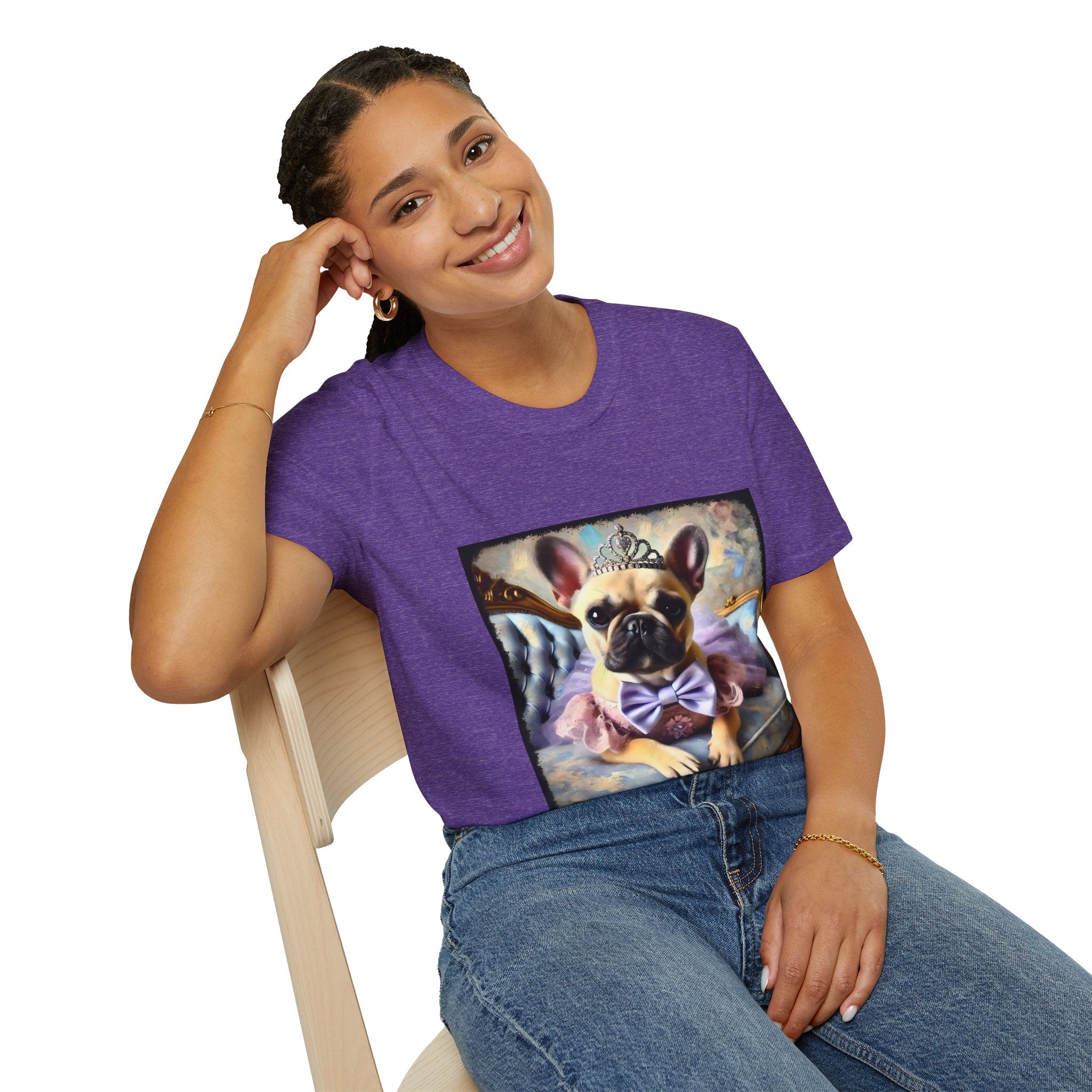 Woman sitting in heather purple dog t-shirt featuring French Bulldog in tiara and tutu on royal chair with dreamy pastel background.