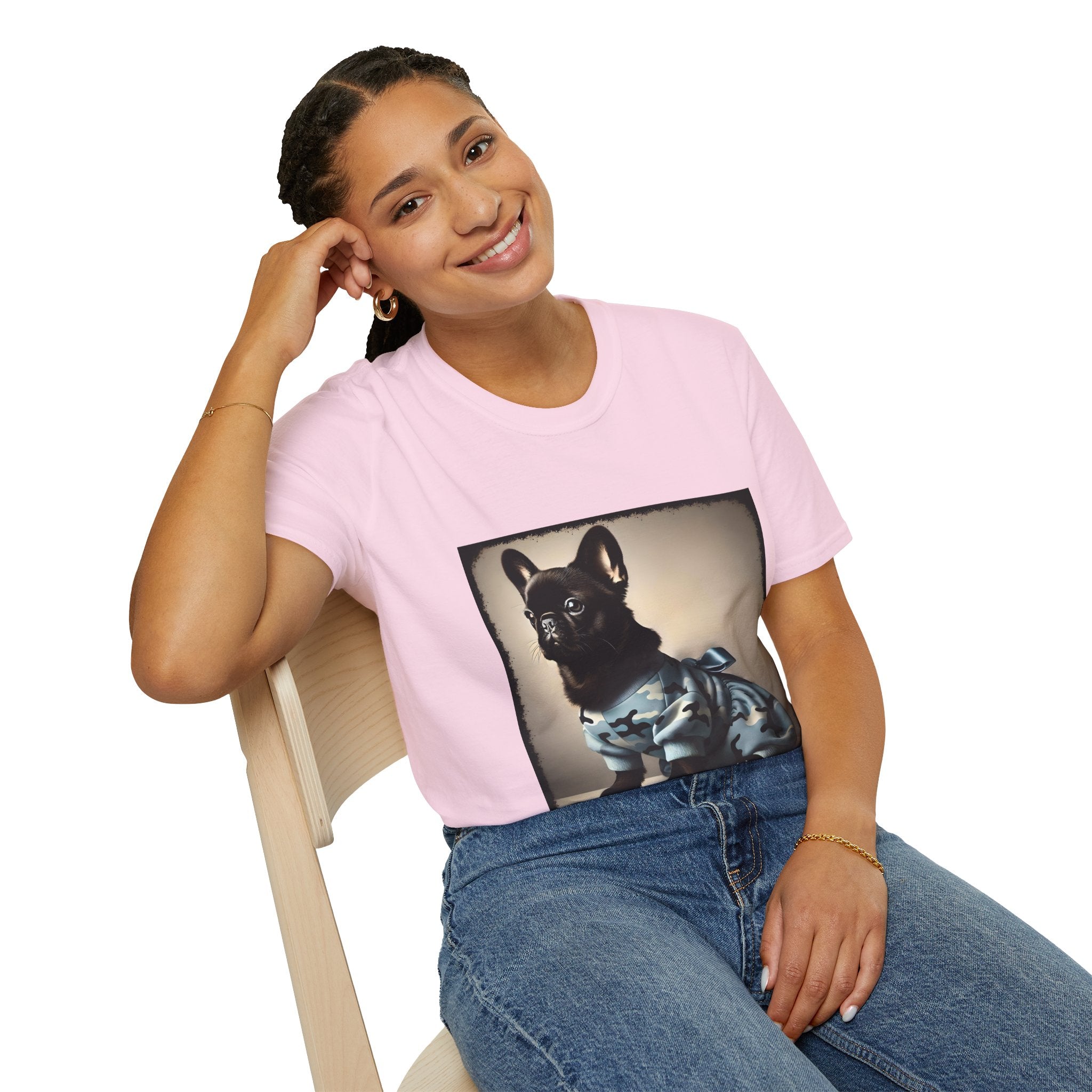 Woman sitting wearing light pink dog t-shirt featuring black French Bulldog in blue camo outfit with bow, set in soft vintage portrait.
