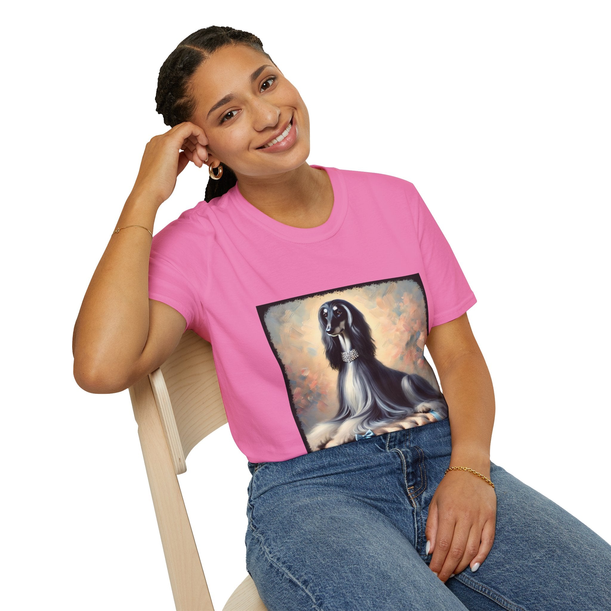 Front view of woman wearing pink dog t-shirt featuring black and white Afghan Hound on cushion with diamond necklace, pastel background
