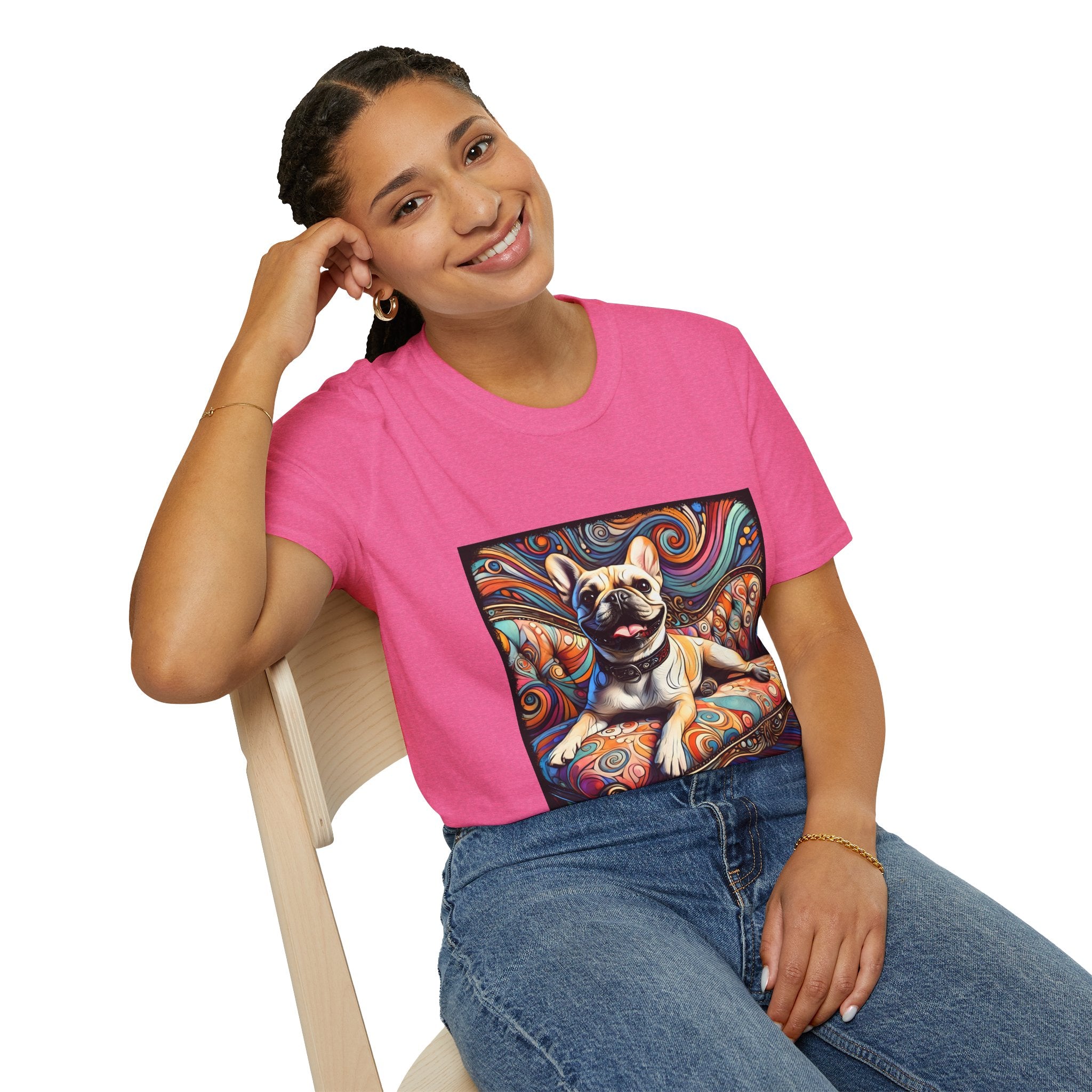 Woman sitting in bright pink dog t-shirt featuring fawn French Bulldog on swirl settee with vivid, colorful background.