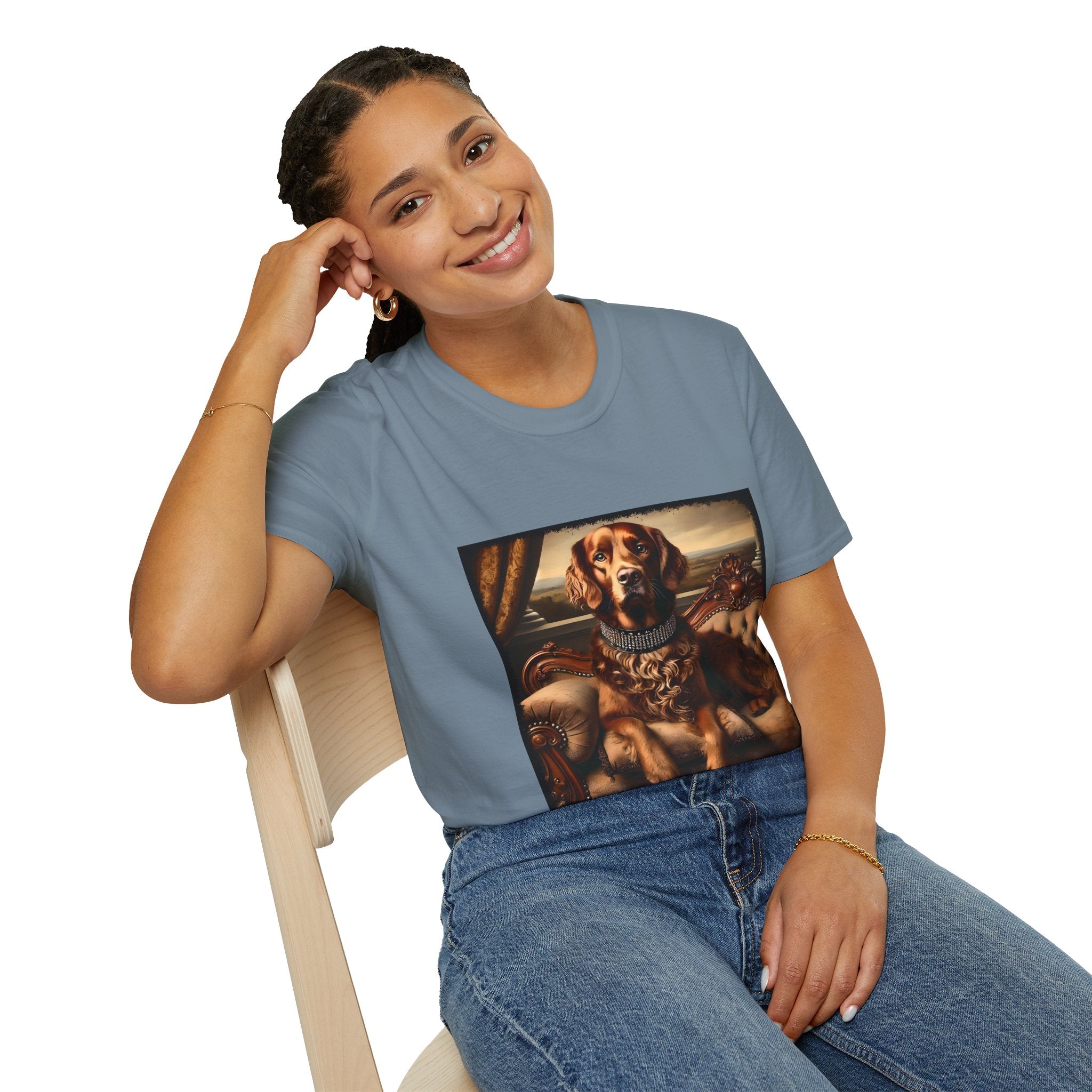 Female model wears stone blue dog t-shirt featuring a chocolate brown golden retriever in a jeweled collar, seated on a vintage tufted settee.