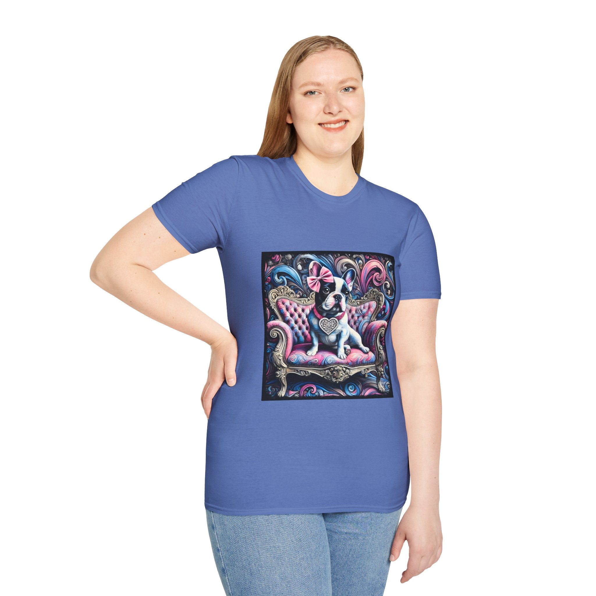 Female model in cornflower blue dog t-shirt featuring a black and white French Bulldog with a pink bow, seated on a tufted pink and gold settee against a swirling blue, pink, and purple expressionist-style background.