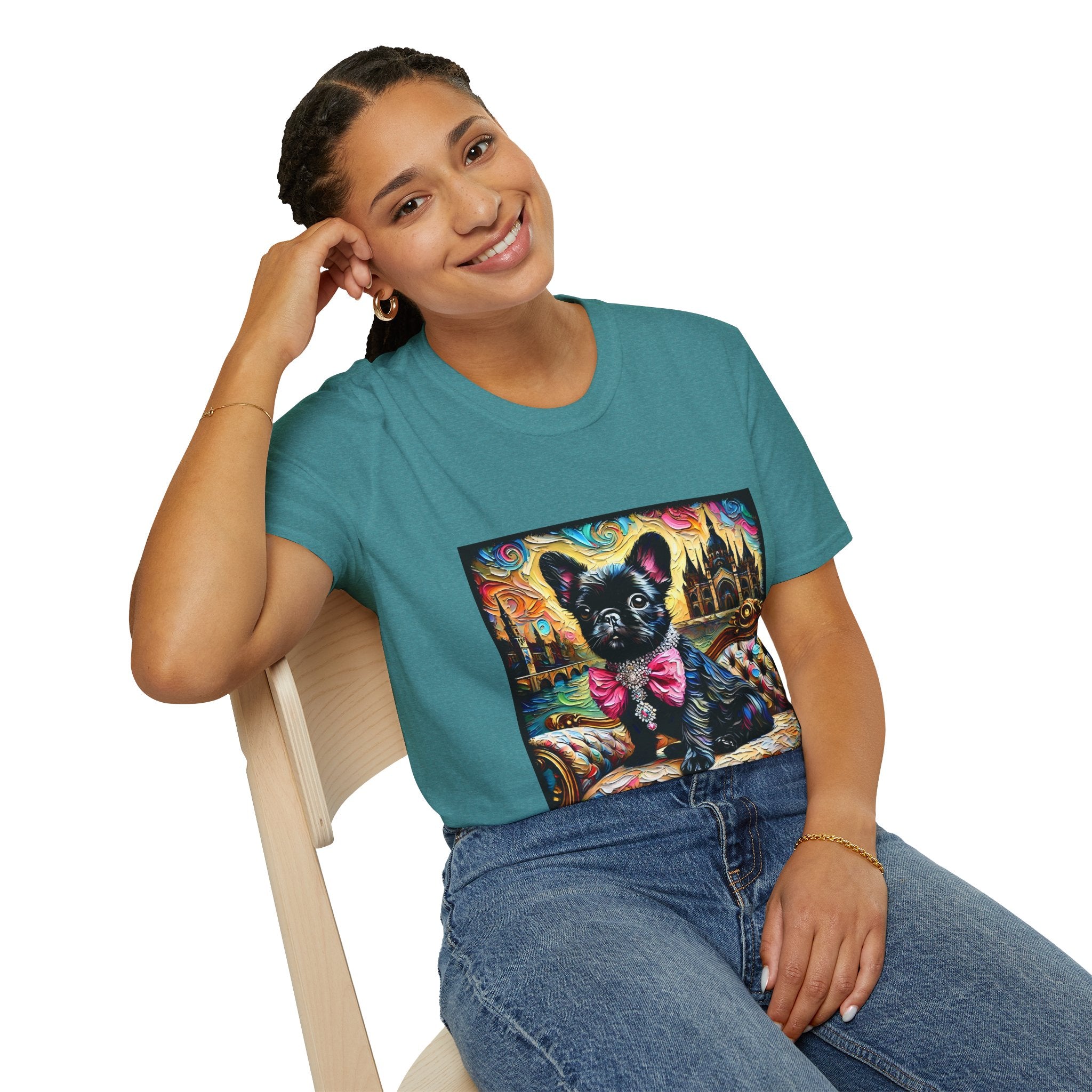 Woman sitting wearing teal dog t-shirt featuring black French Bulldog in jeweled pink bow on settee with vivid castle background.