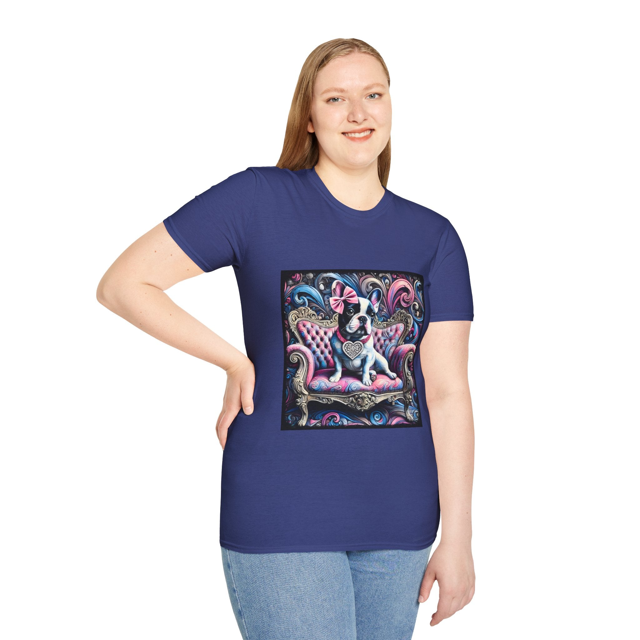 Female model in royal blue dog t-shirt featuring a black and white French Bulldog with a pink bow, seated on a tufted pink and gold settee against a swirling blue, pink, and purple expressionist-style background.