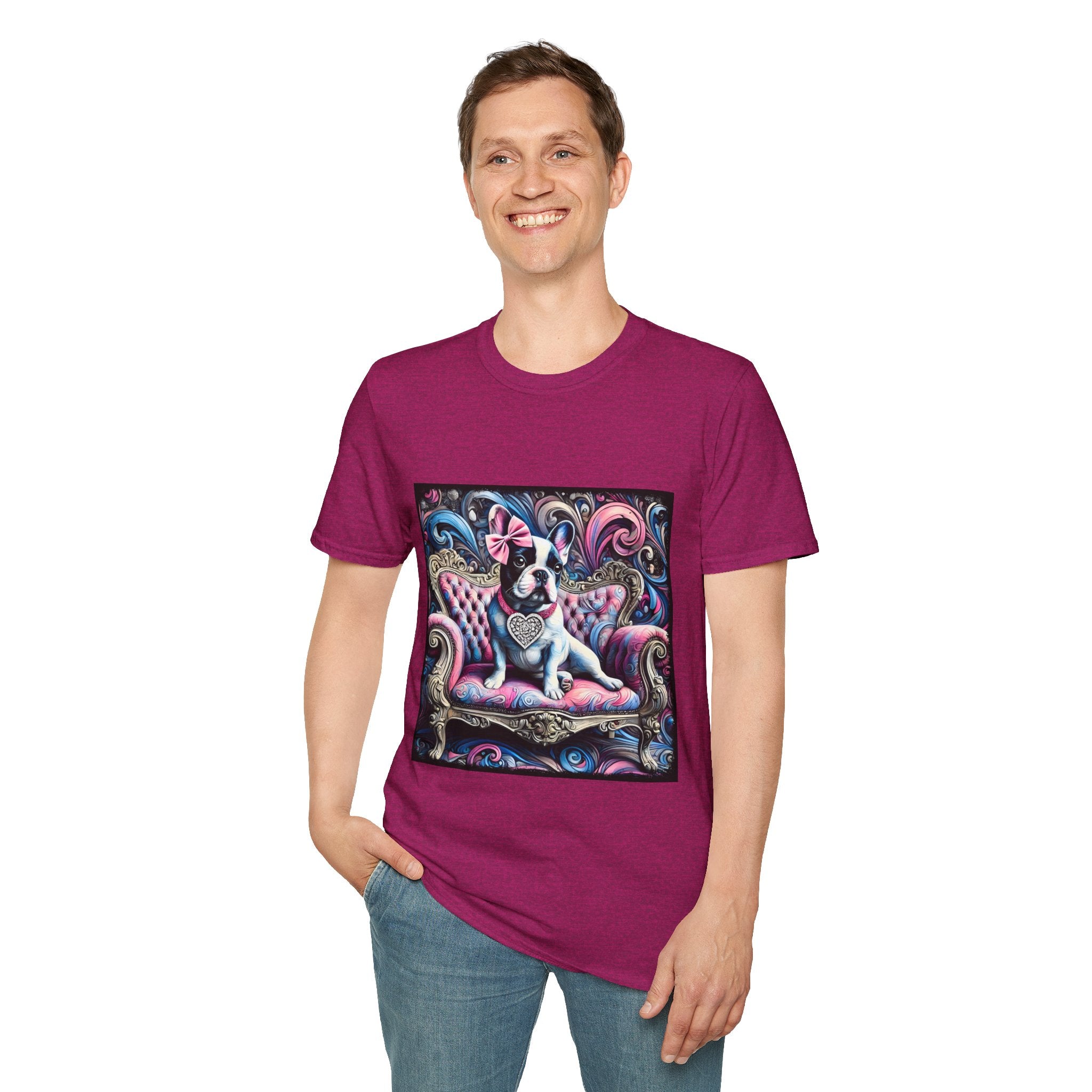 Male model in heather berry dog t-shirt featuring a black and white French Bulldog with a pink bow, seated on a tufted pink and gold settee against a swirling blue, pink, and purple expressionist-style background.