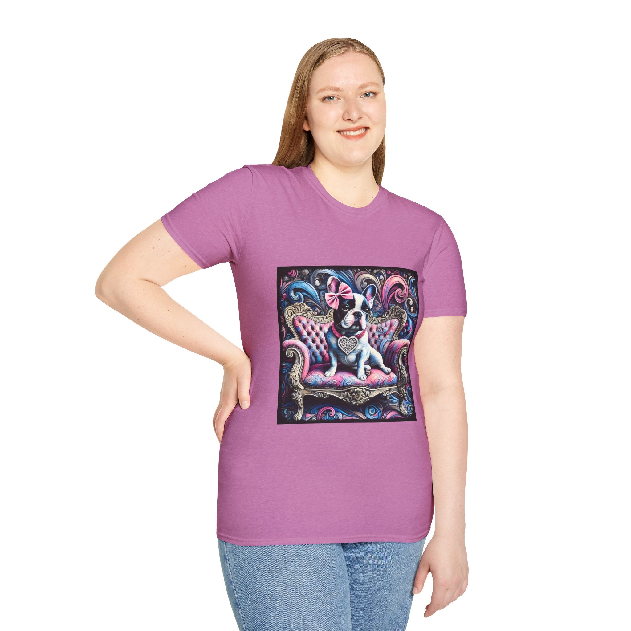 Female model in lilac rose dog t-shirt featuring a black and white French Bulldog with a pink bow, seated on a tufted pink and gold settee against a swirling blue, pink, and purple expressionist-style background.