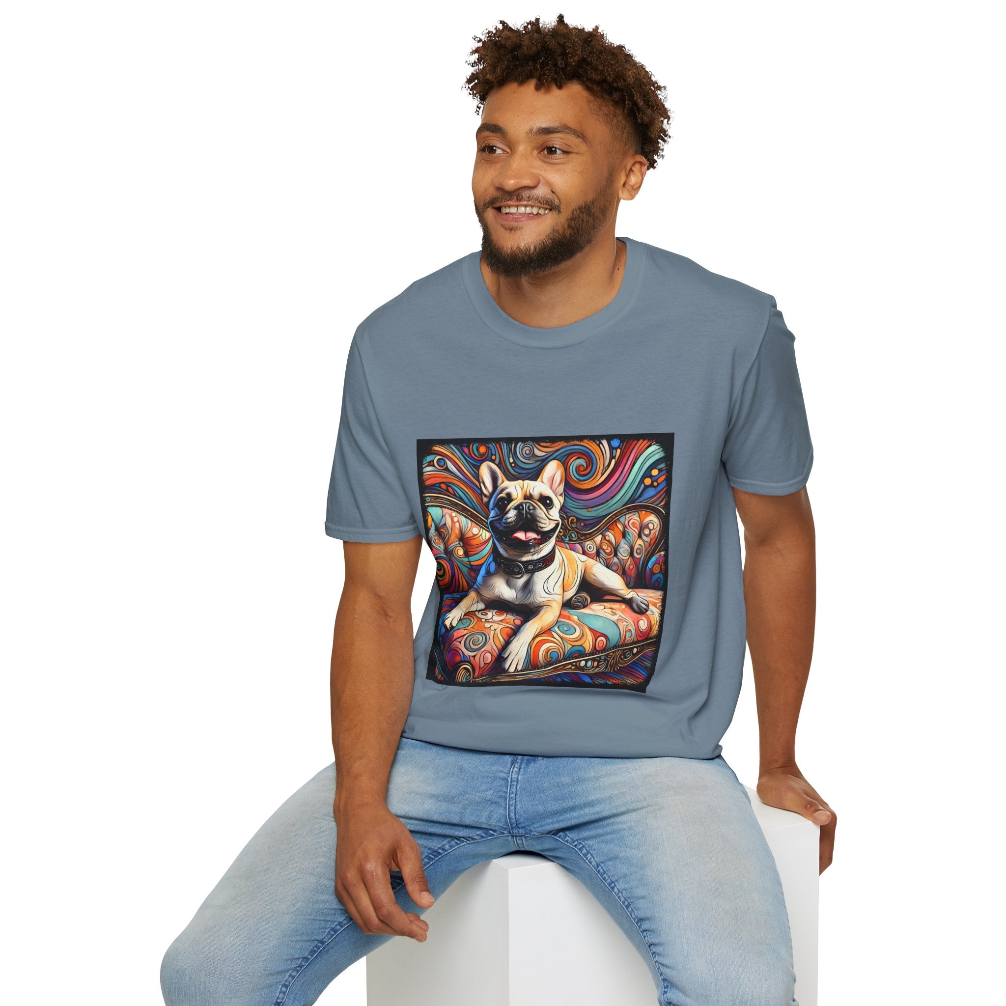 Male model in slate blue blue dog t-shirt featuring fawn French Bulldog with collar on swirl settee and vivid background.