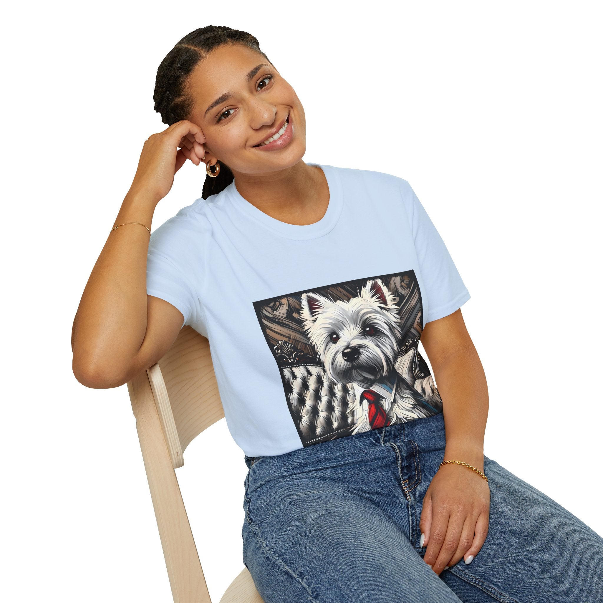 Female model in light blue dog t-shirt featuring a Westie in a red tie seated on a tufted chair in a wood-accent room.