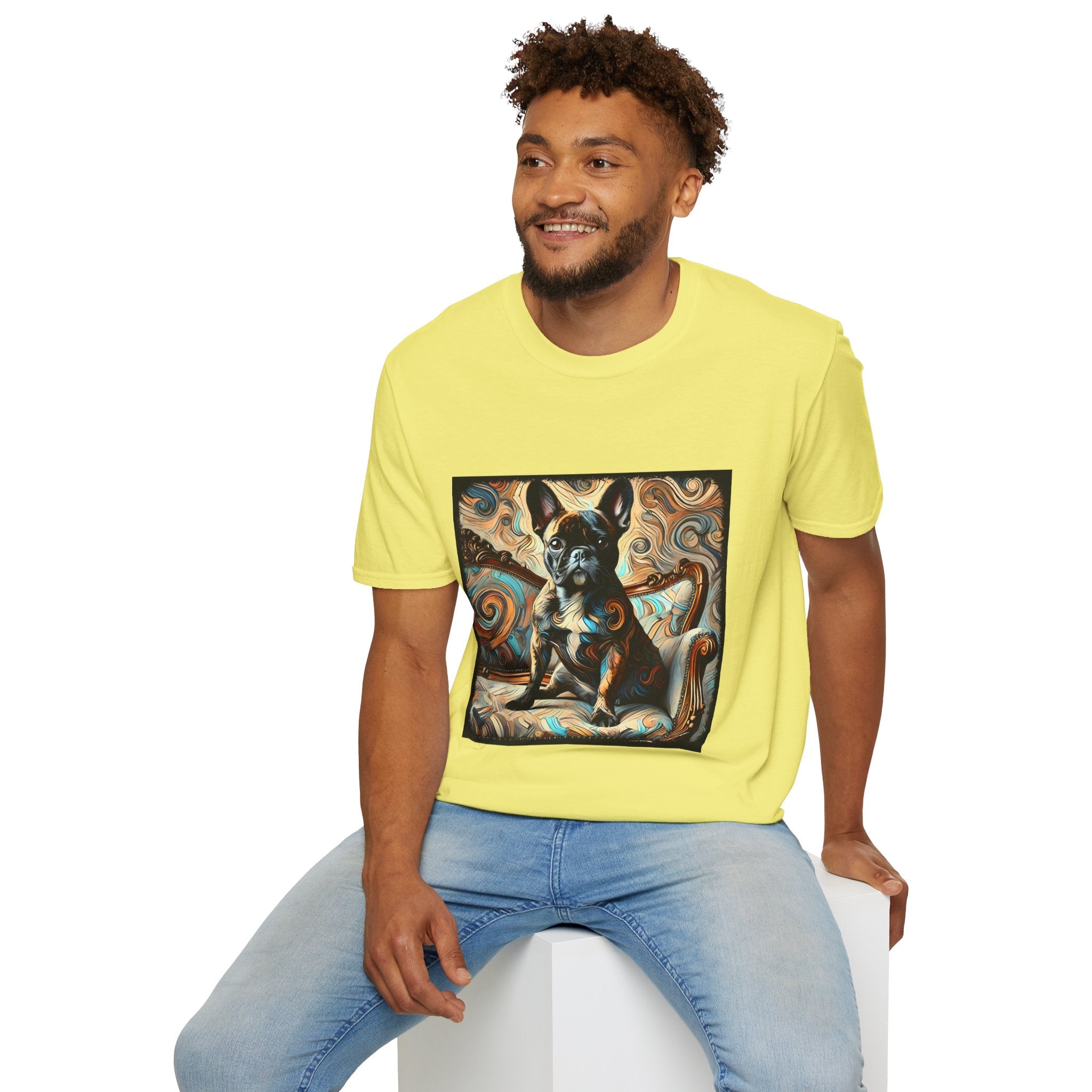 Male model wearing bright yellow dog t-shirt featuring black and tan French Bulldog on ornate settee with swirl pattern background.
